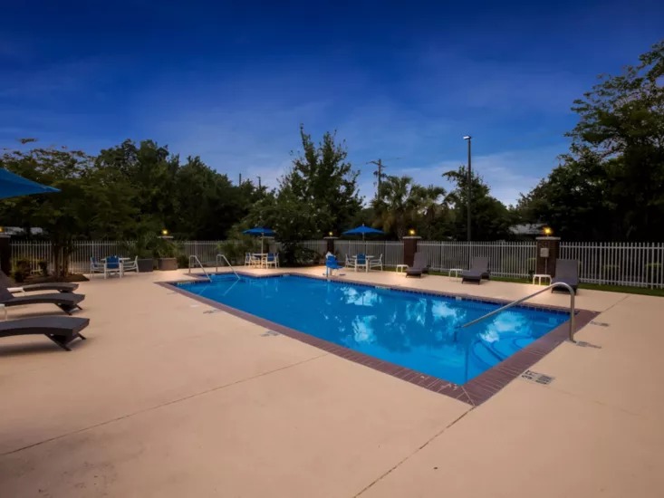 Outdoor swimming pool with lounge chairs on a sunny day